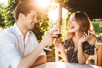 Loving couple sitting in cafe by dating drinking wine