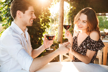 Loving couple sitting in cafe by dating drinking wine