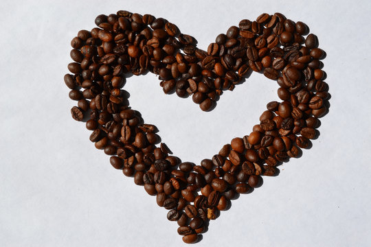 The heart of coffee beans is used as an ornament or background element.