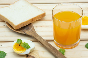 Orange juice in glass with heathy foods on wood table