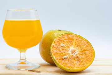 Orange juice in glass with sliced orange on wood table