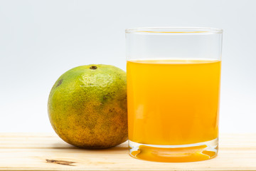 Orange juice in glass with sliced orange on wood table