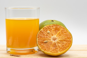 Orange juice in glass with sliced orange on wood table