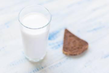 A glass of milk, kefir and a slice of black bread on a wooden background. The concept of healthy nutrition, diet.