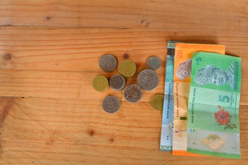 Malaysian Currency. Bank notes and coins on wooden table. selective focus.