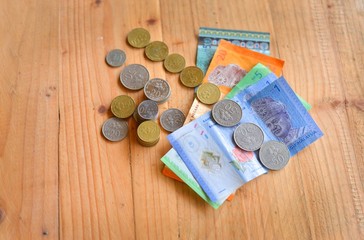 Malaysian Currency. Bank notes and coins on wooden table. selective focus.
