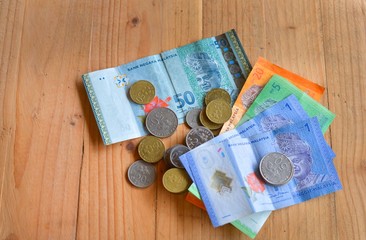 Malaysian currency, Bank notes and coins on wooden table.