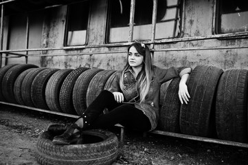 Young hipster girl in jeans jacket and head scarf at tire fitting zone.