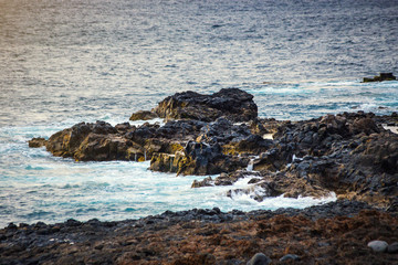Frozen volcanic lava closeup thousands of years after the eruption on background of ocean
