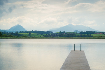 Steg am See in den Bergen am Tag mit Wolken im Sommer