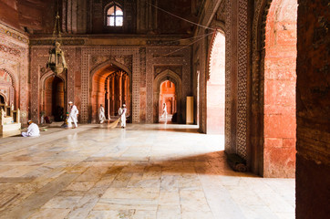 Fototapeta premium AGRA, INDIA - 5 MAY 2015: Mosque workers sweeping the marble floor of the main prayer hall in the Taj Mahal masjid, Agra, India.