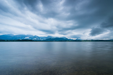Fototapeta na wymiar Wolken übder dem See in den Bergen - Hopfensee im Allgäu