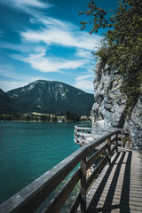 Footbridge at the Wolfgangsee in austria with mountains in the background and clouds on the sky