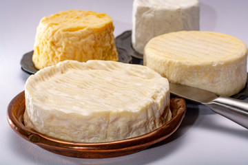 French AOC soft cow cheeses, crumbly Langres with washed rind structure, sharp Pie Angloys, camembert with strong taste and brie served as dessert after dinner