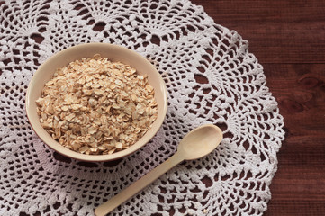 Oatmeal milk, bowl with oatmeal on the wooden table. Healthy living.