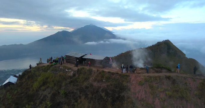 Drone flies over volcano Batur, Bali island, Indonesia. Sunrise, cloudy weather