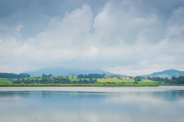 Wolken über dem Hopfensee in den Alpen im Allgäu