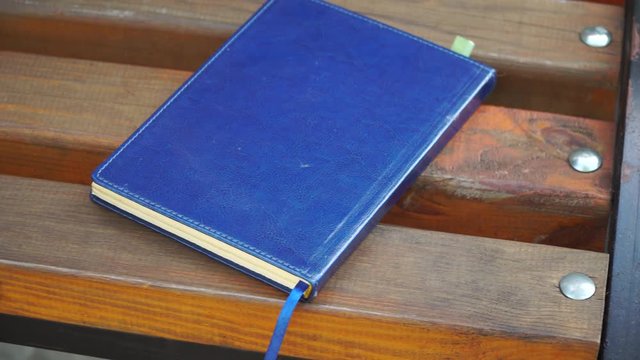 Notebook on bench in park, business concept