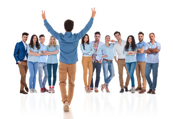 Fototapeta premium young casual man congratulates his colleagues with hands up