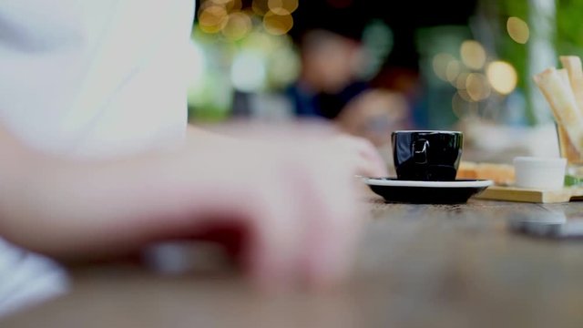 Casual man drinking espresso coffee in cafe with beautiful light bokeh background