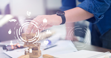 close up on man hand holding wooden block for building tower with all insurance interface concept