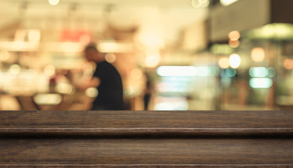 Empty step dark wood table top ( food stand ) with blur customer dining at cafe restaurant...