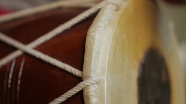 Close up of hands of a man playing a drum.
