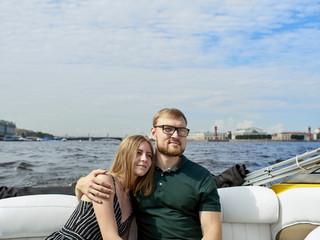 A young couple is traveling on a speedboat.