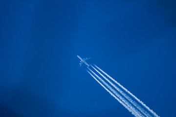 Shot of a jet plane high against the blue sky.