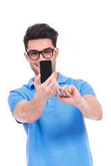 young casual man taking his picture with a mobile camera phone