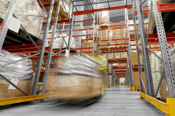 logistic business, shipment and loading concept - motion blurred picture of worker carrying loader...