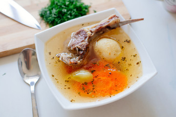 Shurpa is a traditional soup of Central Asian cuisine. Traditional Uzbek or Tatar soup with large sliced vegetables and lamb meat, clear broth, served hot with chopped dill and parsley