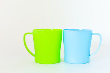 blue and green plastic mug isolated on white background. selective focus.
