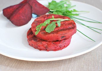 Grilled beetroot burgers on white plate. Vegan healthy food.