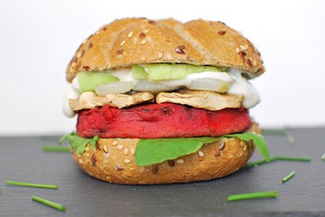 Beetroot burger with avocado, mushrooms, onion and arugula. Vegan food.