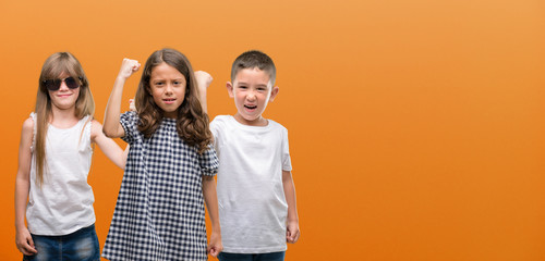 Group of boy and girls kids over orange background annoyed and frustrated shouting with anger, crazy and yelling with raised hand, anger concept © Krakenimages.com