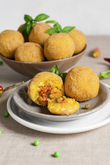 Arancini - italian rice balls which are coated with bread crumbs and then deep fried, filled with ragù (meat and tomato sauce) and peas.