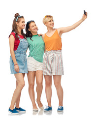 Obraz premium friendship and people concept - group of happy female smiling friends taking selfie by smartphone over white background