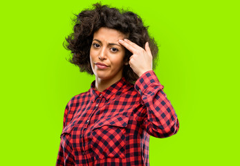 Beautiful arab woman unhappy making suicide gesture, tired of everything. Shoots with hand imitating gun, upset