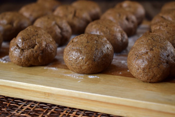 Formed balls of rye yeast dough are ready to be baked on a wooden board