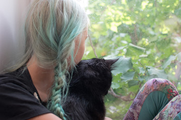 girl teenager on the window with a black cat