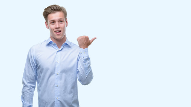 Young handsome blond man pointing with hand and finger up with happy face smiling