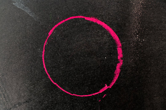 Red chalk drawing in circle shape on black board background