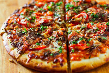 sliced Pizza with Mozzarella cheese, mushrooms, Tomatoes, pepper, Spices and Fresh Basil. Italian pizza.