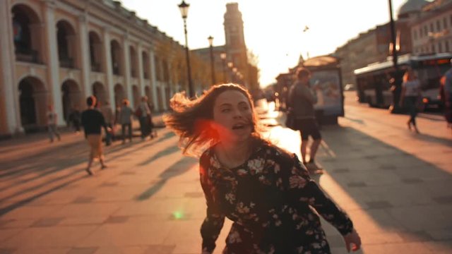 Happy woman crazy dancing at evening sunset street. Slow motion of attractive handsome open uninhibited female of coming weekend and friday ending.