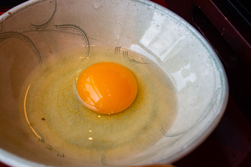 Whole raw fresh organic egg from happy hen in Japanese style bowl. Good for eating raw or as a dipping for sukiyaki or healthy cooking ingredient. Rich with nutrient, benefit, protein and vitamin.