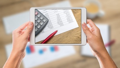 Hands holding tablet with office and calculator screen and white background