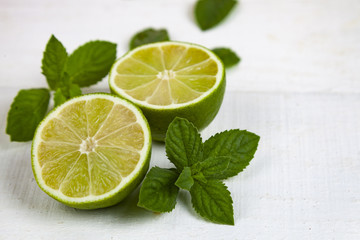 Lime and mint on a white table.