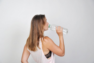 brünette frau trinkt bei hitze im sommer wasser aus flasche