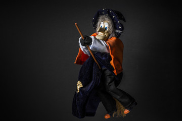 Halloween witch doll isolated on a black background. Halloween decor toy. Closeup